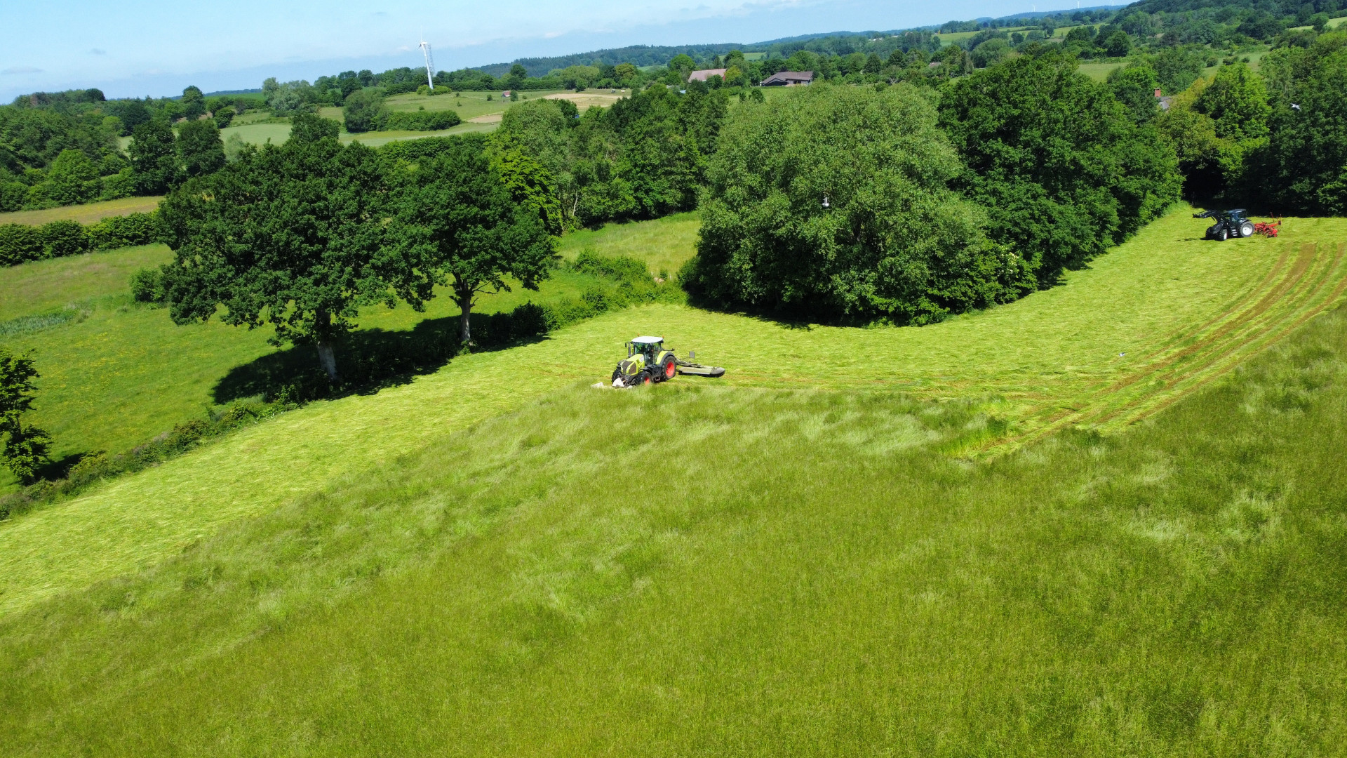 Traktoren fahren auf einem grasbewachsenen Hügel