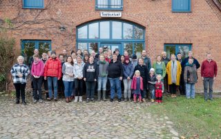 eine Gruppe von Menschen, die vor einem Haus stehen