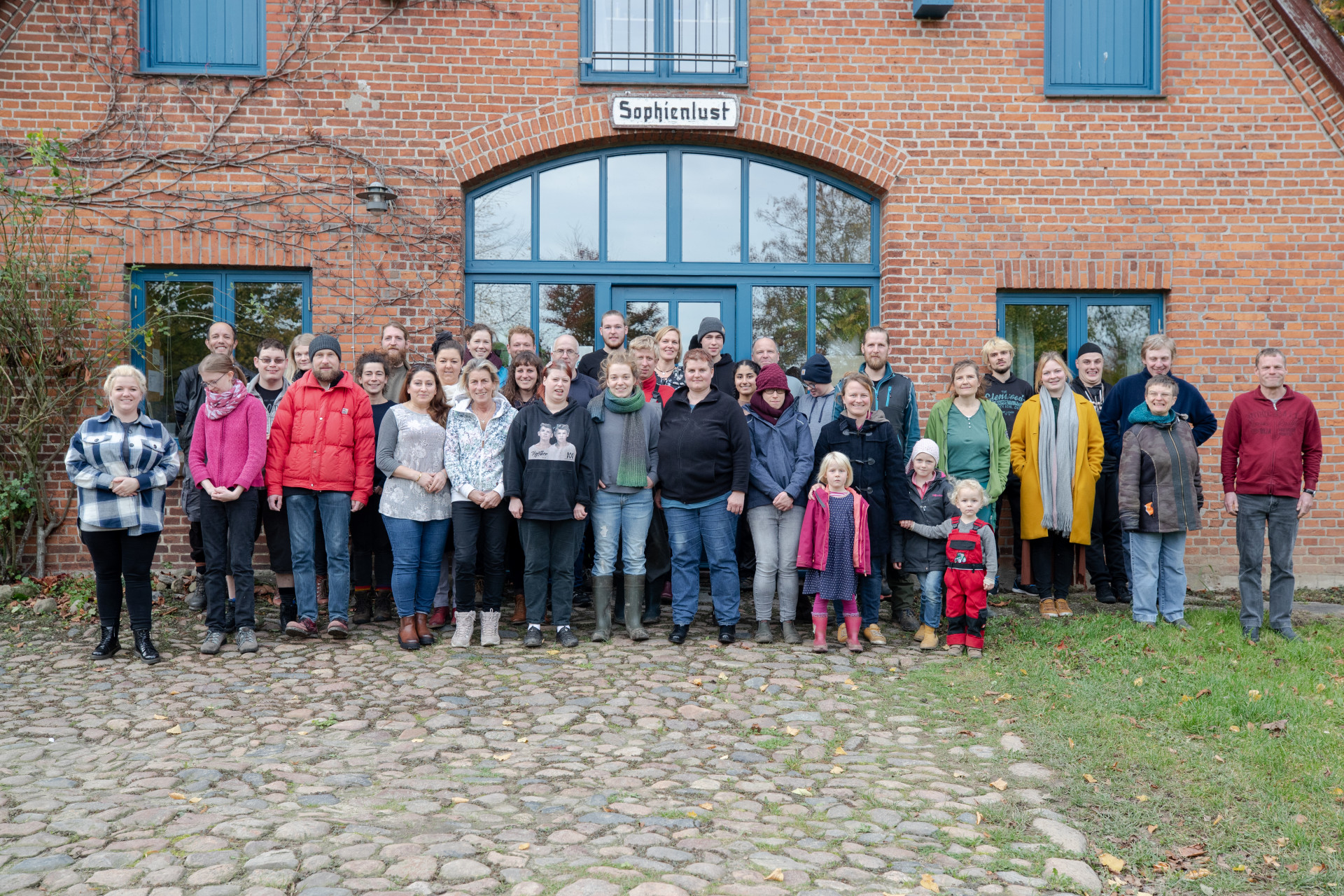 eine Gruppe von Menschen, die vor einem Haus stehen