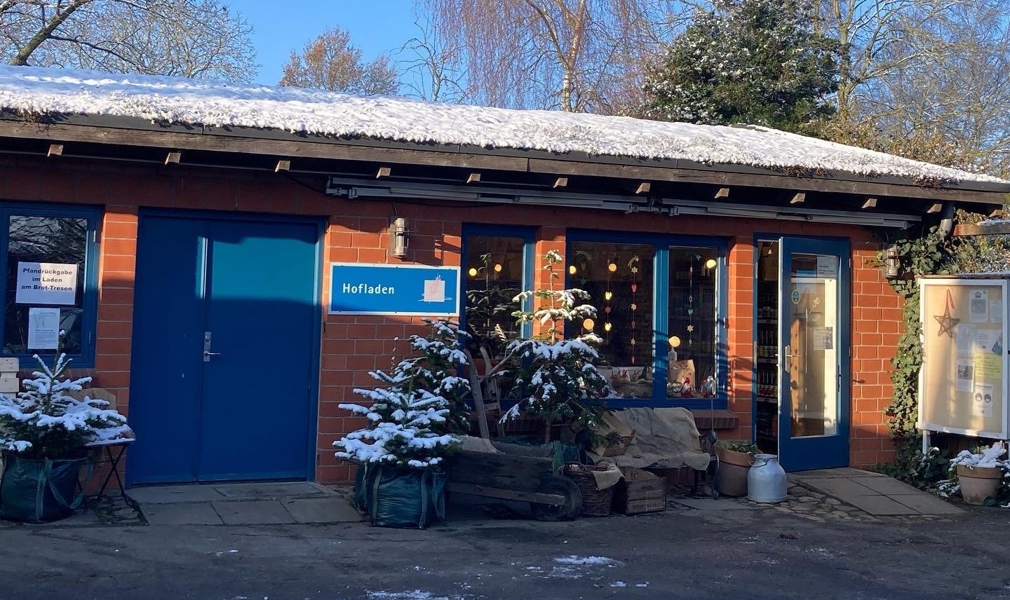 ein kleines Gebäude mit einer blauen Tür und einem schneebedeckten Dach