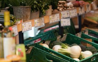 Nahaufnahme der Verkaufsdisplays des Hofladens mit Gemüse und Kräutern
